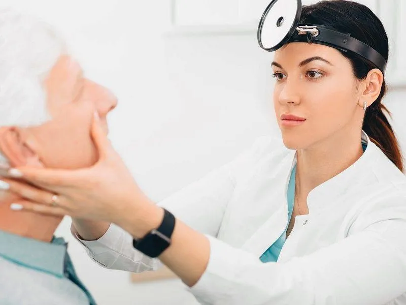 Clinician examining a patient during a sinus evaluation