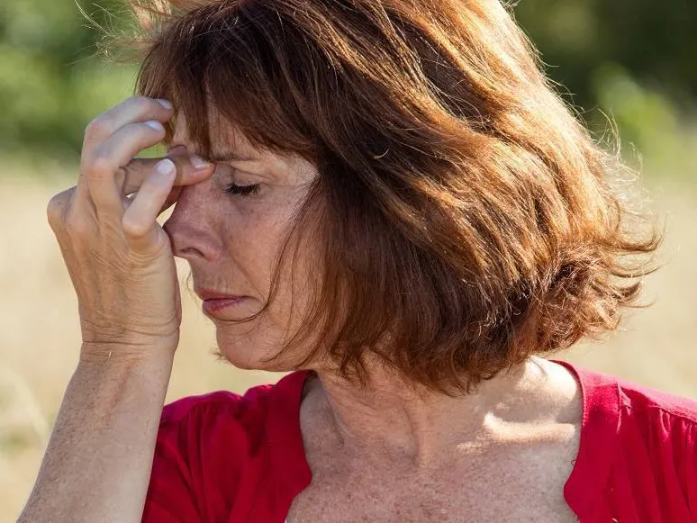 Woman pressing the bridge of her nose in sinus discomfort